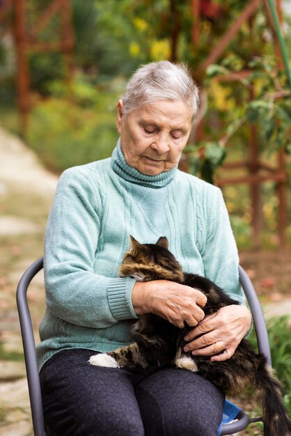 Vista frontale della donna anziana con il gatto presso la casa di cura