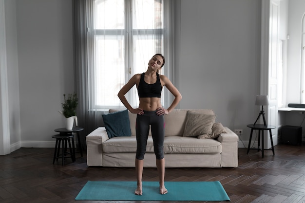 Vista frontale della donna che allunga prima dell'yoga