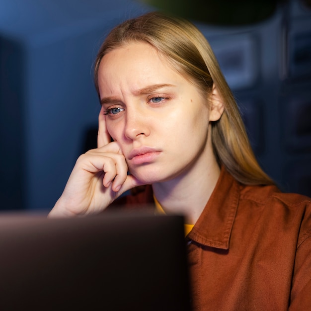 Vista frontale della donna che esamina computer portatile