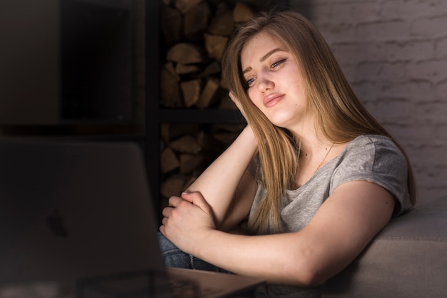 Vista frontale della donna che esamina il suo computer portatile