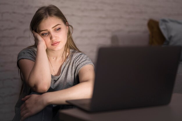 Vista frontale della donna che esamina il suo computer portatile