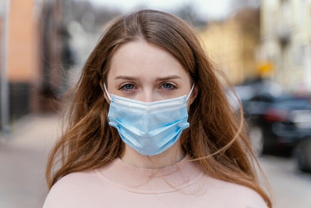 Vista frontale della donna che indossa la mascherina medica in città