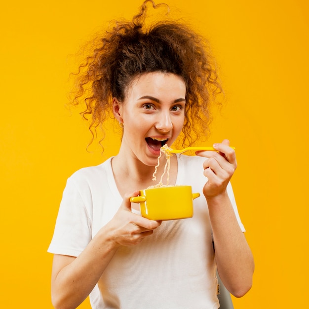 Vista frontale della donna che mangia le tagliatelle