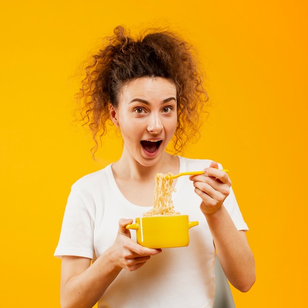 Vista frontale della donna che mangia le tagliatelle