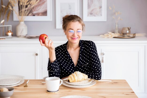 Vista frontale della donna che mangia prima colazione