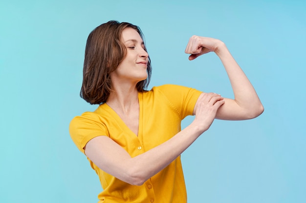 Vista frontale della donna che mostra il suo forte bicipite