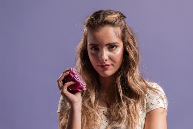 Vista frontale della donna che posa con una rosa e uno spazio della copia