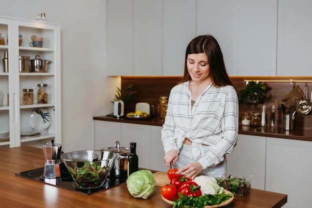 Vista frontale della donna che prepara il cibo in cucina