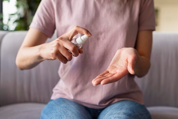 Vista frontale della donna che usando i disinfettanti