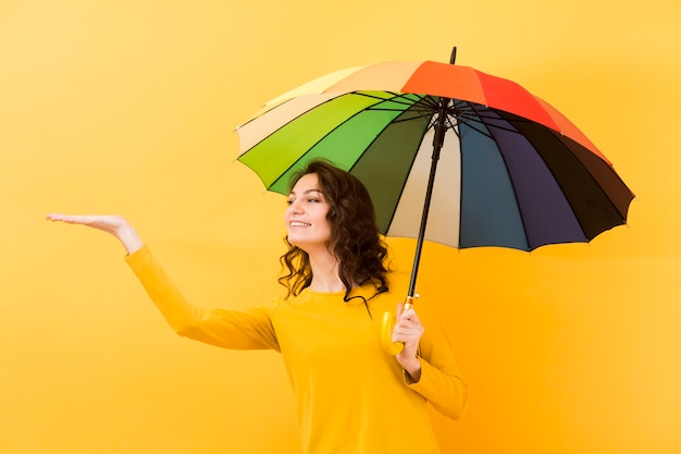 Vista frontale della donna con l'ombrello dell'arcobaleno