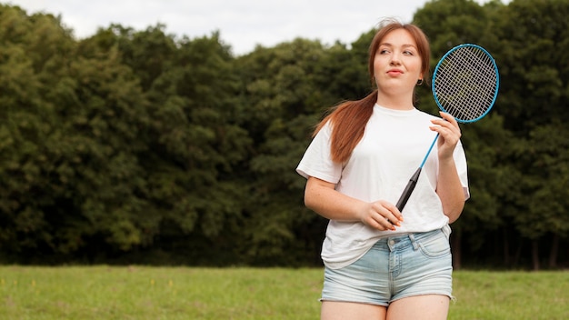 Vista frontale della donna con la racchetta all'aperto