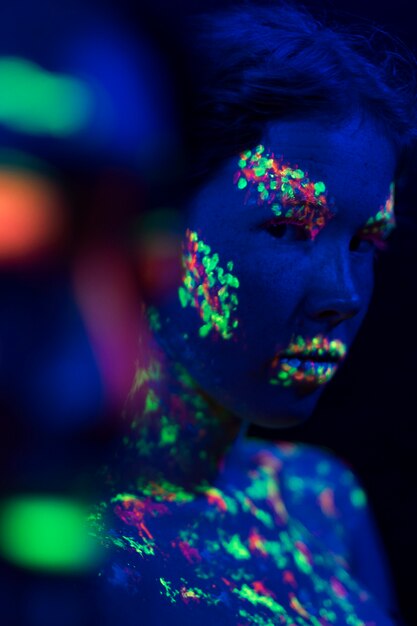Vista frontale della donna con trucco fluorescente