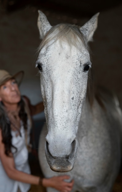 Vista frontale della donna contadina con il suo cavallo