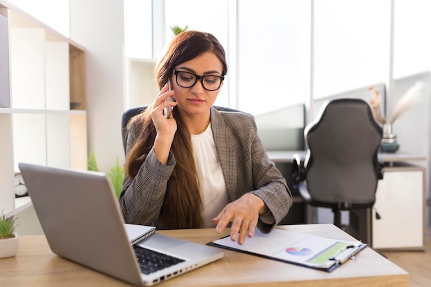 Vista frontale della donna di affari che lavora alla scrivania in ufficio