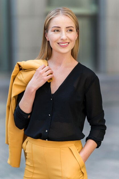 Vista frontale della donna di affari di smiley che propone all'aperto