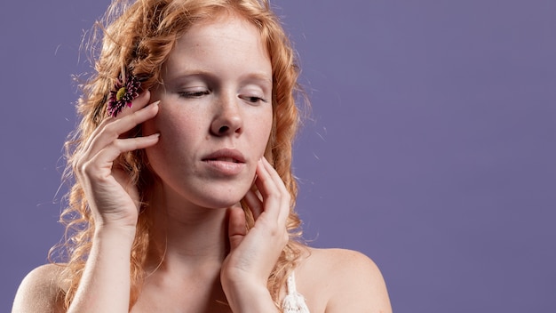 Vista frontale della donna di redhead che propone con le sue mani e spazio della copia