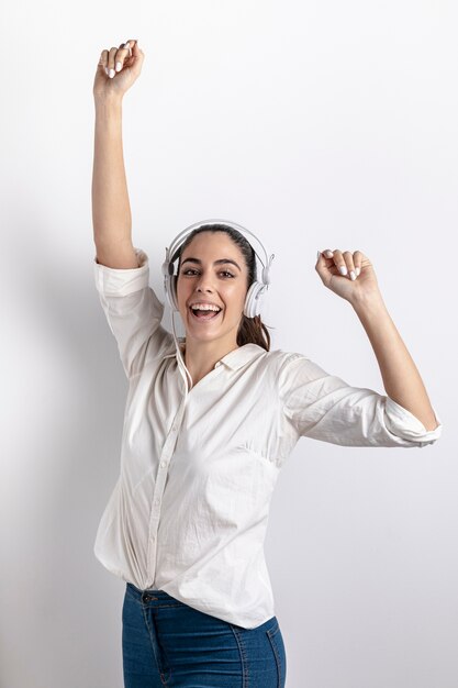 Vista frontale della donna di smiley con il dancing delle cuffie