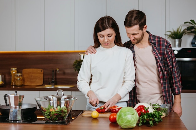 Vista frontale della donna e dell'uomo che preparano il cibo in cucina