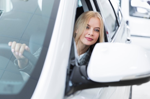 Vista frontale della donna in automobile bianca