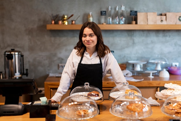 Vista frontale della donna in grembiule alla caffetteria