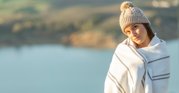 Vista frontale della donna in posa con una coperta durante un viaggio su strada