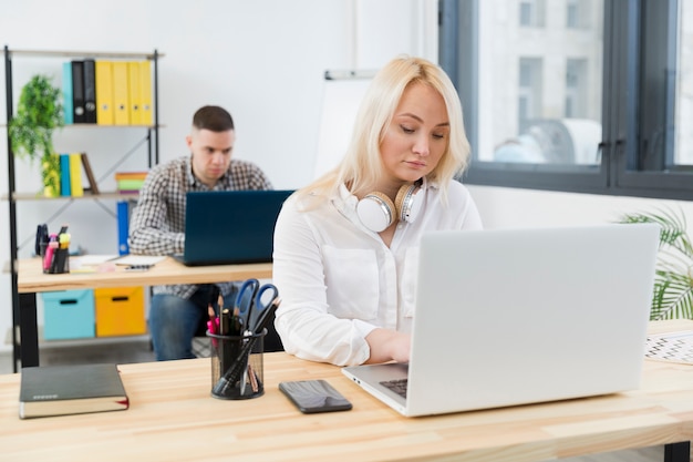 Vista frontale della donna in sedia a rotelle che lavora dal suo scrittorio all'ufficio