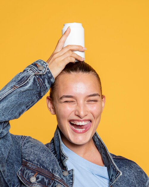 Vista frontale della donna sorridente con la lattina di soda