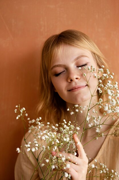 Vista frontale della donna sorridente in posa con i fiori