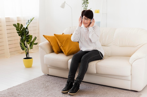 Vista frontale della donna sul divano con le cuffie