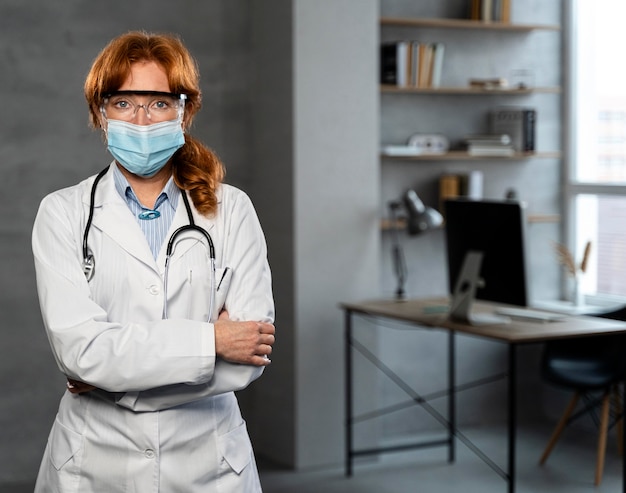 Vista frontale della dottoressa con maschera medica e copia spazio