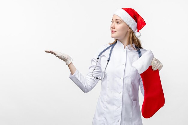 Vista frontale della dottoressa con un grande calzino natalizio sul muro bianco