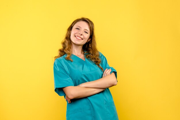 Vista frontale della dottoressa sorridente sulla parete gialla