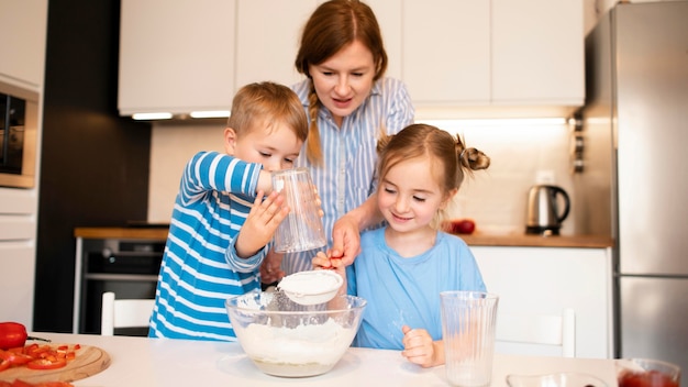 Vista frontale della famiglia che cucina a casa