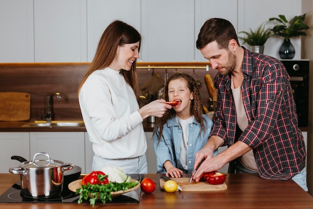 Vista frontale della famiglia che prepara il cibo a casa