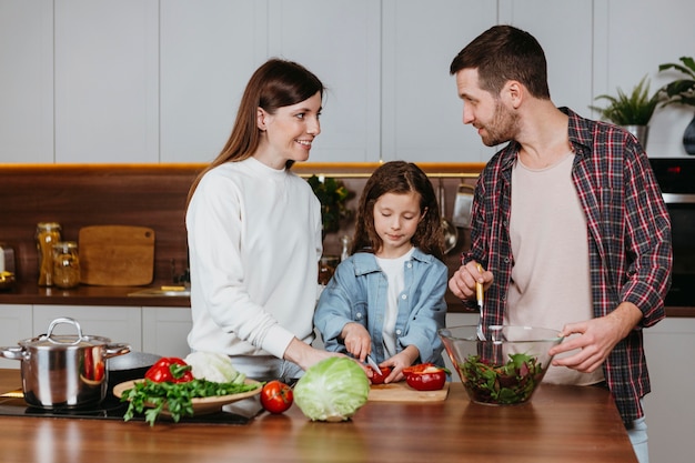 Vista frontale della famiglia che prepara il cibo in cucina