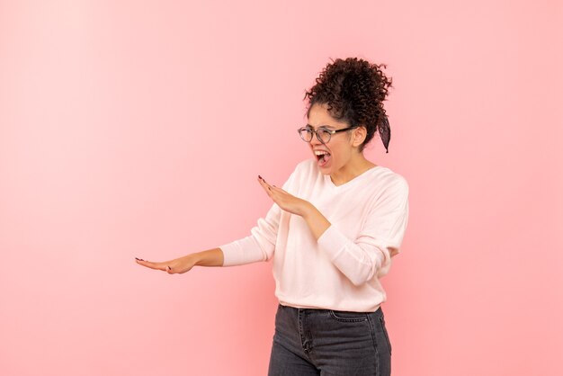 Vista frontale della femmina graziosa che grida sul rosa