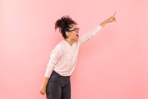 Vista frontale della femmina graziosa che grida sul rosa