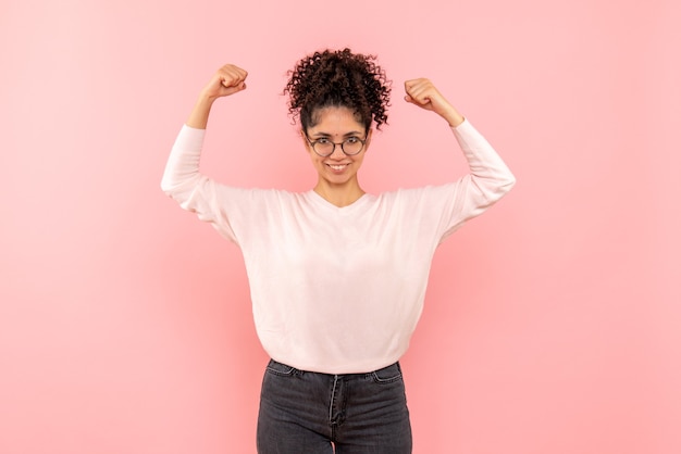 Vista frontale della femmina graziosa che si rallegra sul rosa