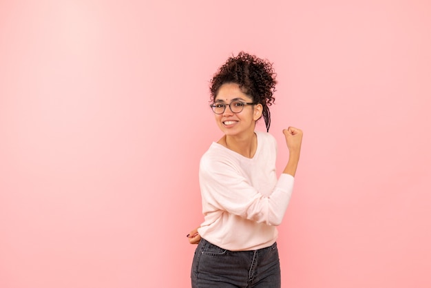 Vista frontale della femmina graziosa che si rallegra sul rosa