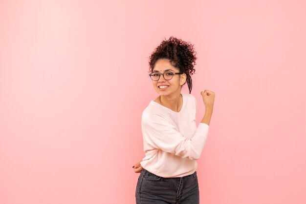 Vista frontale della femmina graziosa che si rallegra sul rosa