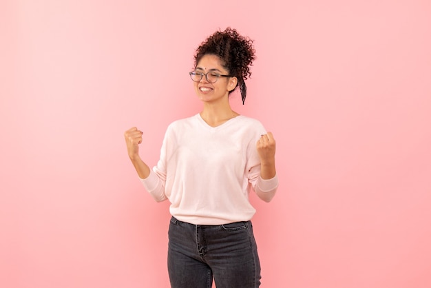 Vista frontale della femmina graziosa che si rallegra sul rosa