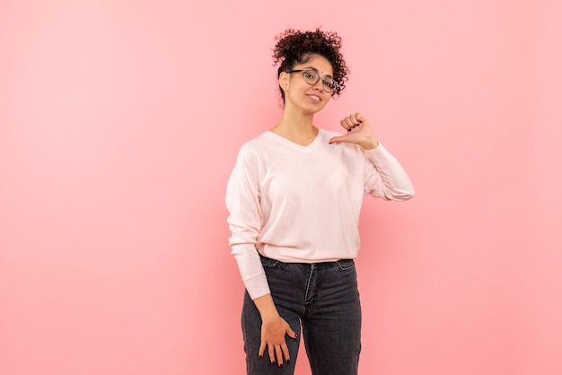 Vista frontale della femmina graziosa deliziata sul rosa