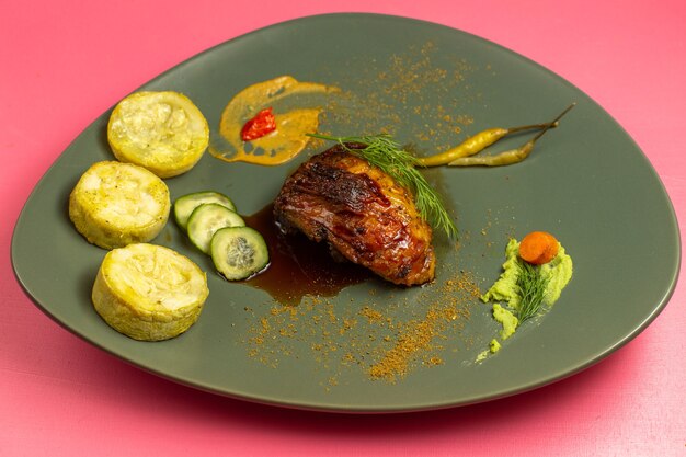 Vista frontale della fetta di carne fritta con zucche cotte all'interno del piatto sulla superficie rosa