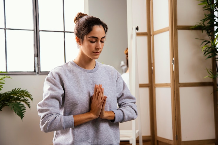 Foto gratuito vista frontale della giovane donna che fa yoga a casa