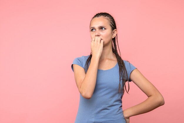 Vista frontale della giovane donna che pensa sul rosa