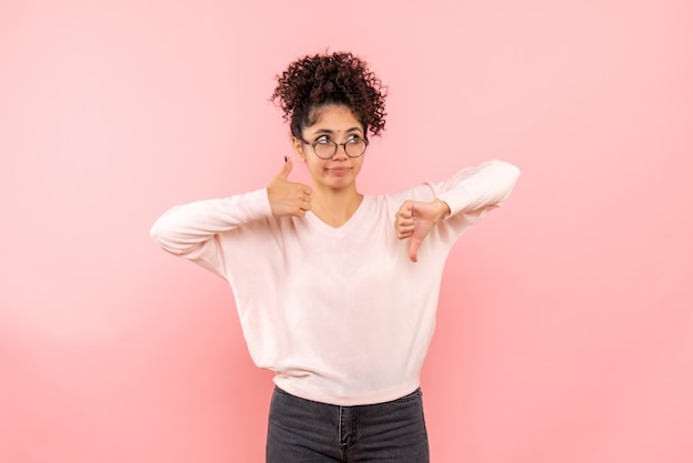 Vista frontale della giovane donna che pensa sulla parete rosa