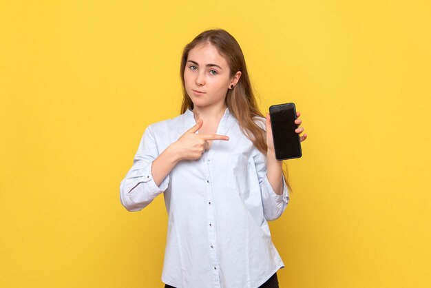 Vista frontale della giovane donna che tiene il telefono