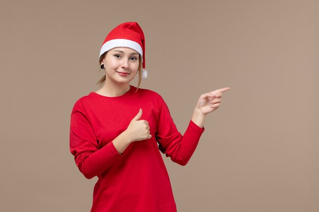Vista frontale della giovane donna con mantello natalizio su marrone
