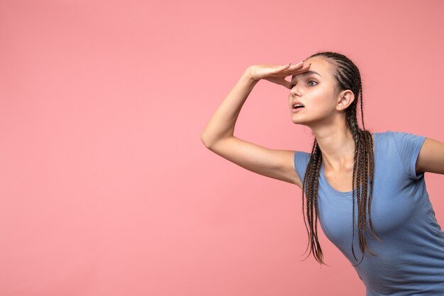 Vista frontale della giovane donna guardando la distanza sul rosa