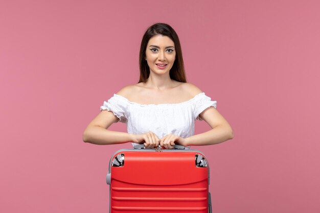 Vista frontale della giovane donna in piedi e si prepara per la vacanza sullo sfondo rosa viaggio mare viaggio donna vacanza all'estero